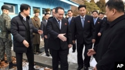 朝鲜和平统一委员会主席李善权（中）在板门店非军事区走过边界时与迎接他的韩国官员握手（2018年1月9日）