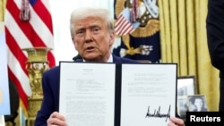 Tổng thống Donald Trump cầm sắc lệnh tăng thuế quan tại Phòng Bầu dục, Tòa Bạch ốc, ngày 13/2/2025.