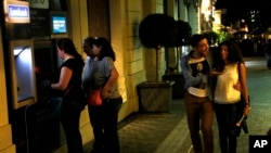 星期一早晨，一对希腊夫妇路过雅典的自动取款机。