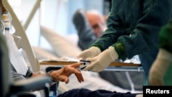 A coronavirus patient is treated in an intensive care unit in Cremona, Italy, March 19, 2020.
