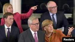 星期二歐盟委員會主席容克(中)批評歐盟成員國沒有迅速採取行動。德國總理默克爾(右)