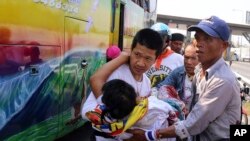 曼谷的泰國反政府抗議者把一名受傷的同伴抬上救護車。(2014年4月1日)