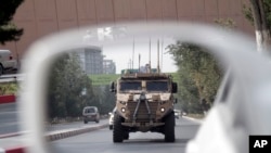 一辆巡逻的美国装甲车在阿富汗喀布尔的一面汽车的镜子中反映出来。