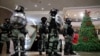 香港防暴警察在一个商场中站在一棵圣诞树旁面对示威者。（2019年12月24日）