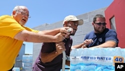 美国亚利桑那州凤凰城人们因极端高温警告为庇护所捐赠瓶装水。