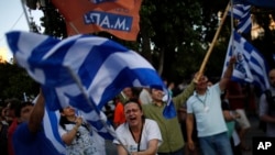 希臘公佈了最新的全民公投結果之後，表示不接受債權人救助方案的人揮動希臘國旗。