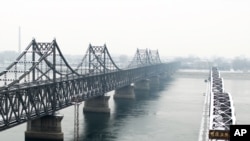 丹东横跨鸭绿江的中朝友谊桥和鸭绿江断桥。（资料照）