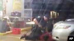 视频截图显示，奥尔顿•斯特林2016年7月5日在路易斯安那州巴吞鲁日的一家便利店外受到两名警察拘留