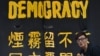 一位香港民主抗议者站在一条横幅前。（2014年9月30日）