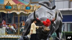 2018年7月9日北京一家零售和批发服装商场外面的铜牛雕塑。