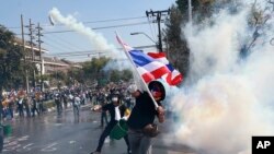 12月1日在曼谷，反政府示威者把警方发射的催泪瓦斯瓶扔回去