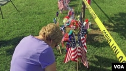 一名妇女在美国田纳西州查塔努加枪击现场附近哀悼丧生的四名海军陆战队队员。一名海军士官后来伤重不治而死。（美国之音贝恩拍摄）