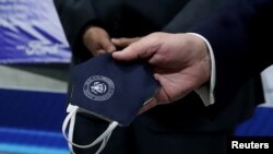 口罩是戴還是不戴？這是一個各執己見的問題。圖為路透社捕捉到美國總統特朗普2020年5月21日訪問密西根州一間汽車製造廠時，手拿著口罩的情景。（路透社資料照）