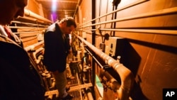 This photo provided by New York state governor's office shows Gov. Andrew Cuomo on a catwalk, looking into the cell that inmates escaped from at a maximum-security prison near the Canadian border in Dannemora, N.Y., June 6, 2015. 