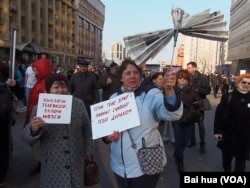 4月13日的莫斯科媒体自由集会上，两名妇女手举标语抗议媒体谎言宣传。左边标语：关掉电视，启动大脑思考。右侧标语：如果对你撒谎，那意味着他们认为你是傻瓜。 (美国之音白桦拍摄)