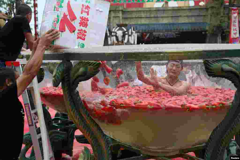 2017年8月12日，中国湖南省宁乡风景区，一名男子坐在装满红辣椒的水桶中，参加吃辣椒比赛。