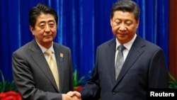 安倍晉三與習近平2014年11月10日在北京出席亞太經合會期間見面握手（資料圖片）