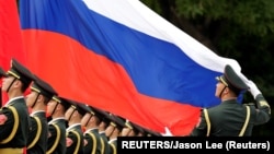 資料照：中國解放軍儀仗隊手舉俄羅斯國旗接受俄羅斯總統普京的檢閱。 （2018年6月8日）