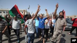 利比亚人高举被油墨染色已示投过票的手指在首都烈士广场欢庆(2012年7月7日)