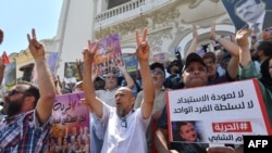 Raia wa Tunisia wakibeba mabango wakati wa maandamano mjini Tunis kutaka wafungwa wa kisiasa kuachiliwa huru.