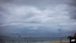 A tourist walks on the beach before the expected arrival of Hurricane Lorena, in Los Cabos, Mexico, Friday, Sept. 20, 2019.