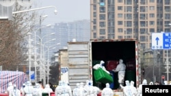 身穿防護服的工人在清理清理武漢華南海鮮市場。這裡曾被認為是新冠病毒的發源地。（2020年3月4日）