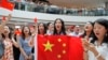 亲北京的支持者手举中国国旗在香港金融中心商场唱中国国歌。（2019年9月12日）