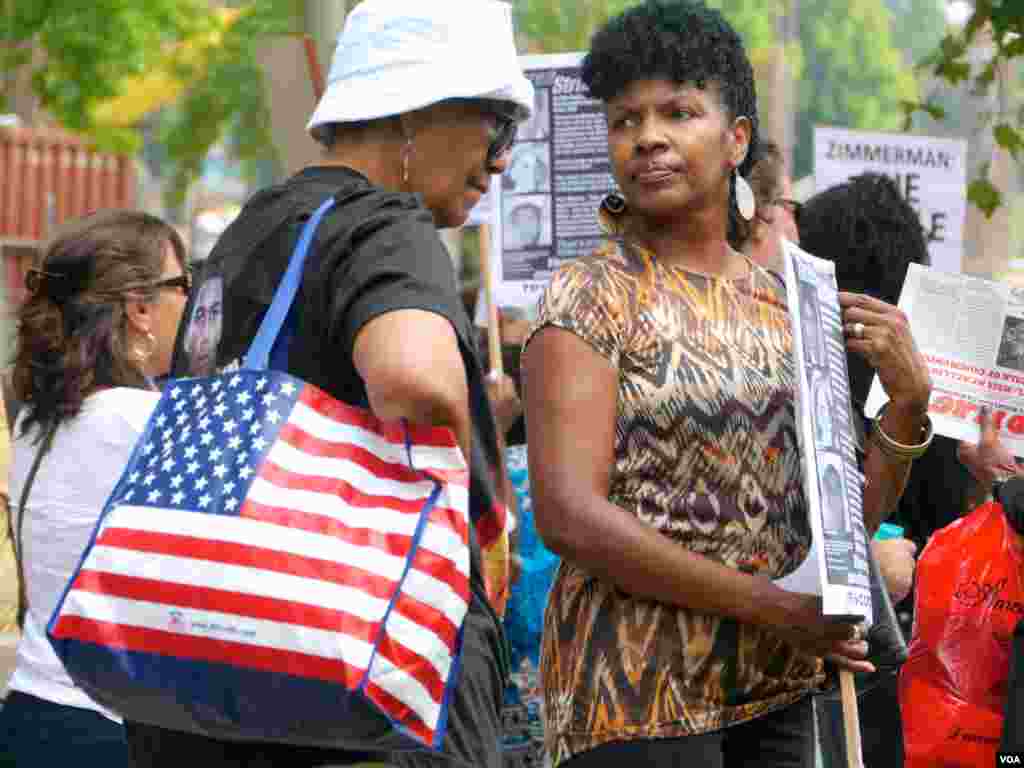 穿着马丁头像短袖衫的女士背着鲜明的国旗袋（美国之音国符拍摄）