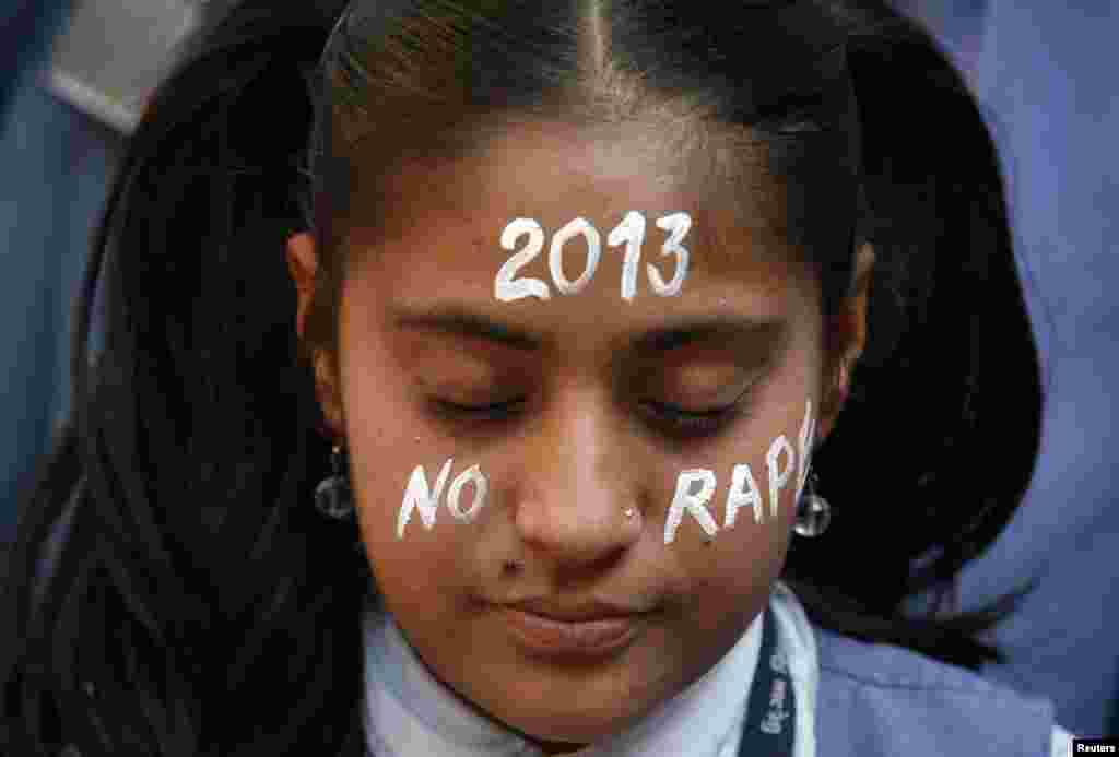 一名學生2012年12月31日在印度艾哈邁達巴德一個悼念在新德里被輪姦致死的一名女子的燭光守夜上祈禱。