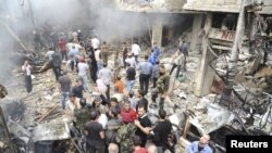 一批民眾星期一在大馬士革街區的一棟被炸毀的大樓前聚集