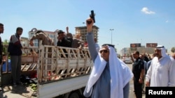 4月24日在为逊尼派抗议者送葬的队伍中一人朝天开枪，这些人死于和政府军冲突中