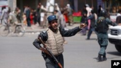 在8月7号的一起爆炸事件后，一名阿富汗警察守卫现场