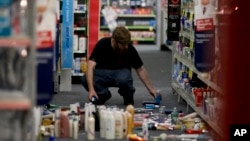 2014年3月28日晚，加州洛杉磯附近拉米拉達市一商店職工在收拾地震中散落的商品