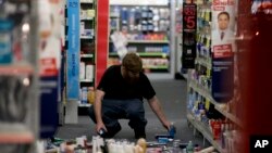 2014年3月28日晚，加州洛杉矶附近拉米拉达市一商店职工在收拾地震中散落的商品
