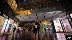 ​ປະ​ຊາ​ຊົນ ຈີນ ຍ່າງ​ເລາະ​ຢູ່​ຫ້າງ​ຊັບ​ພະ​ສິນ​ຄ້າ.