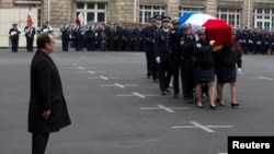 法国总统奥朗德在巴黎为殉职警察举行的仪式上行注目礼