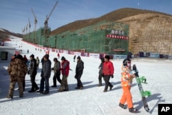 河北省一座滑雪场上的民工、滑雪者和正在建造的滑雪公寓。如果北京获得冬奥主办权，部分比赛将在这里举行（2014年12月6日）