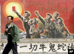 一人走过银川郊外一家电影制片厂的文革宣传画。邓小平否定文革，他在文革中曾被名列牛鬼蛇神(资料照片)