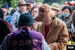 台湾人安基金会的工作人员对申请者做简单的身份识别后即送出午餐邀请单。（美国之音记者方正拍摄）