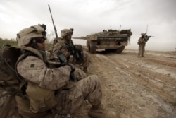 美國海軍陸戰隊在阿富汗馬爾亞城邊東北方一條交通要道巡邏時經過一輛丹麥陸軍豹2A5坦克。（2010年2月21日）