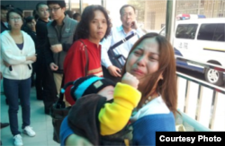 母亲一边抱着小孩一边在哭诉（图片来自新世纪新闻/网民提供）