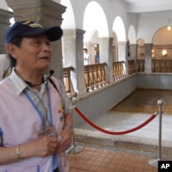 义务导游蔡聪敏在公共温泉浴池旁