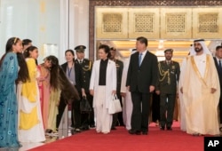 阿联酋统治者、副总统兼总理穆罕默德欢迎中国国家主席习近平和夫人彭丽媛。图上的阿联酋女子是欢迎仪式上的舞蹈者。