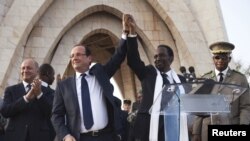 France's President Francois Hollande (2nd L) joins hands with Mali's interim president Dioncounda Traore at Independence Plaza in Bamako, Mali February 2, 2013.