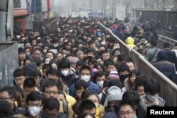 2015年12月8日，在北京首次发布空气污染红色警报后，乘客在地铁站排队