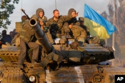 乌克兰军人在港口城市马里乌波尔乘坐在坦克上。2014 9月5日摄