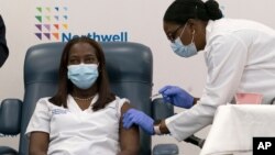 Sandra Lindsay, left, a nurse at Long Island Jewish Medical Center, is inoculated with the Pfizer-BioNTech COVID-19 vaccine by Dr. Michelle Chester, Dec. 14, 2020, in the Queens borough of New York.