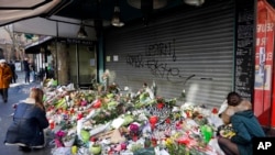 哀悼者把鲜花和蜡烛放在出事的巴黎餐厅前面（2015年11月15日）