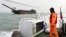 A Taiwanese coast guard looks at a sand-dredging ship with Chinese flag in the waters off the Taiwan-controlled Matsu islands, January 28, 2021. (REUTERS/Ann Wang)