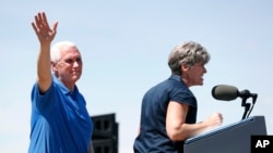 2017年6月3日，艾奥瓦州共和党籍参议员乔尼·恩斯特在该州布恩的年度筹款集会上讲话，身旁的副总统彭斯在向支持者挥手致意。